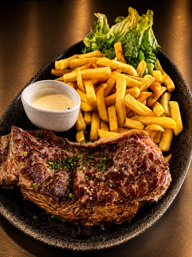Entrecôte grillée à la ciboulette, frites maison, salade verte et sauce onctueuse