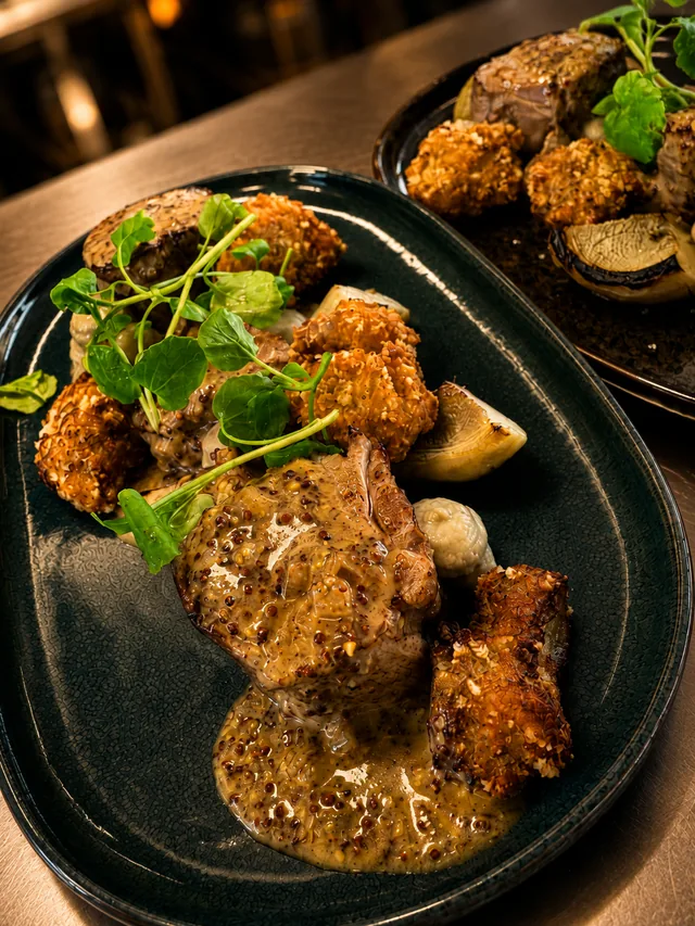 Filet mignon nappé de sauce moutarde, artichauts grillés, croquettes dorées et cresson
